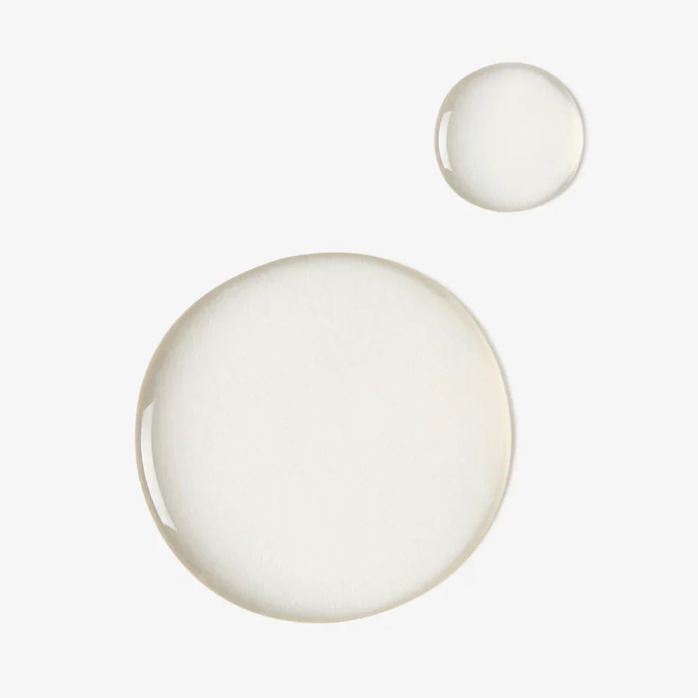 Close-up of clear serum drops, skincare product texture on white background