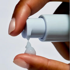Close-up of gel serum being dispensed onto a fingertip, skincare product texture visible