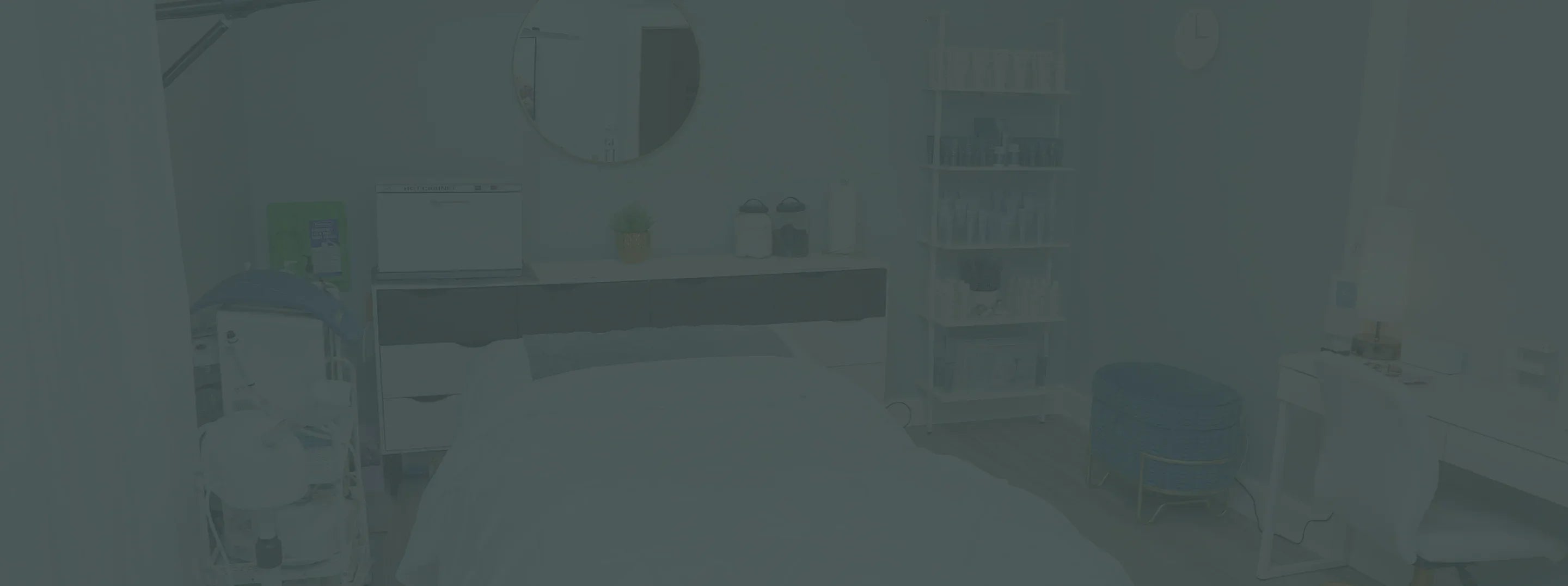 Modern facial treatment room with skincare products, treatment bed, and serene decor.