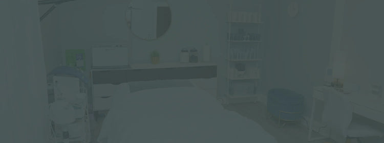 Modern facial treatment room with skincare products, treatment bed, and serene decor.