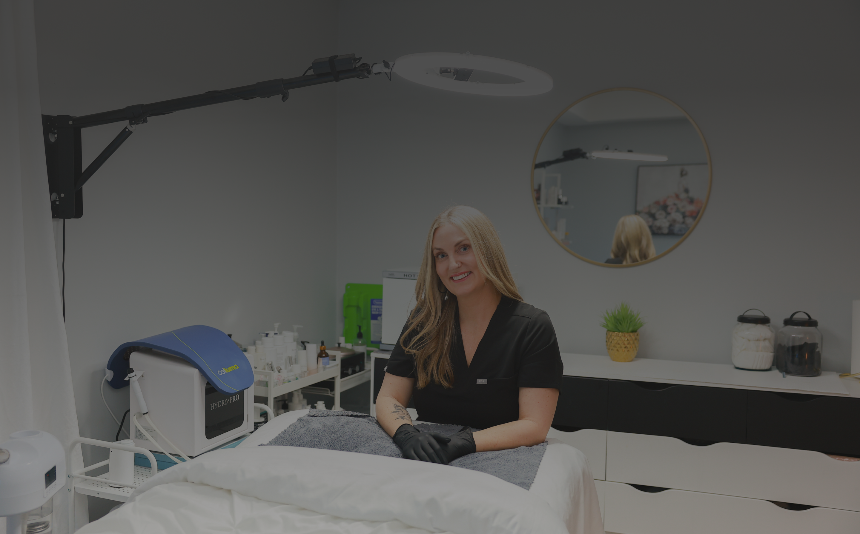 Woman in a medical or clinical setting with equipment and a mirror.